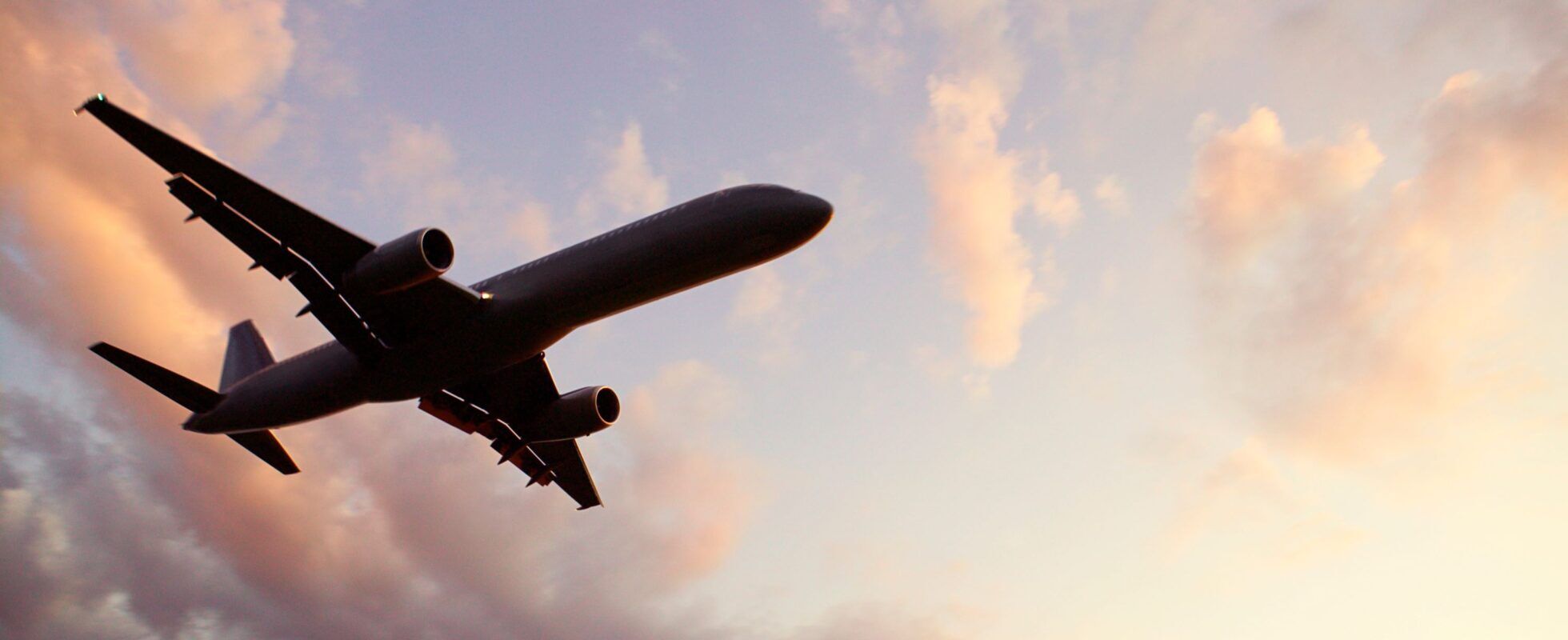 Flugzeug von unten mit Wolken im Hintergrund